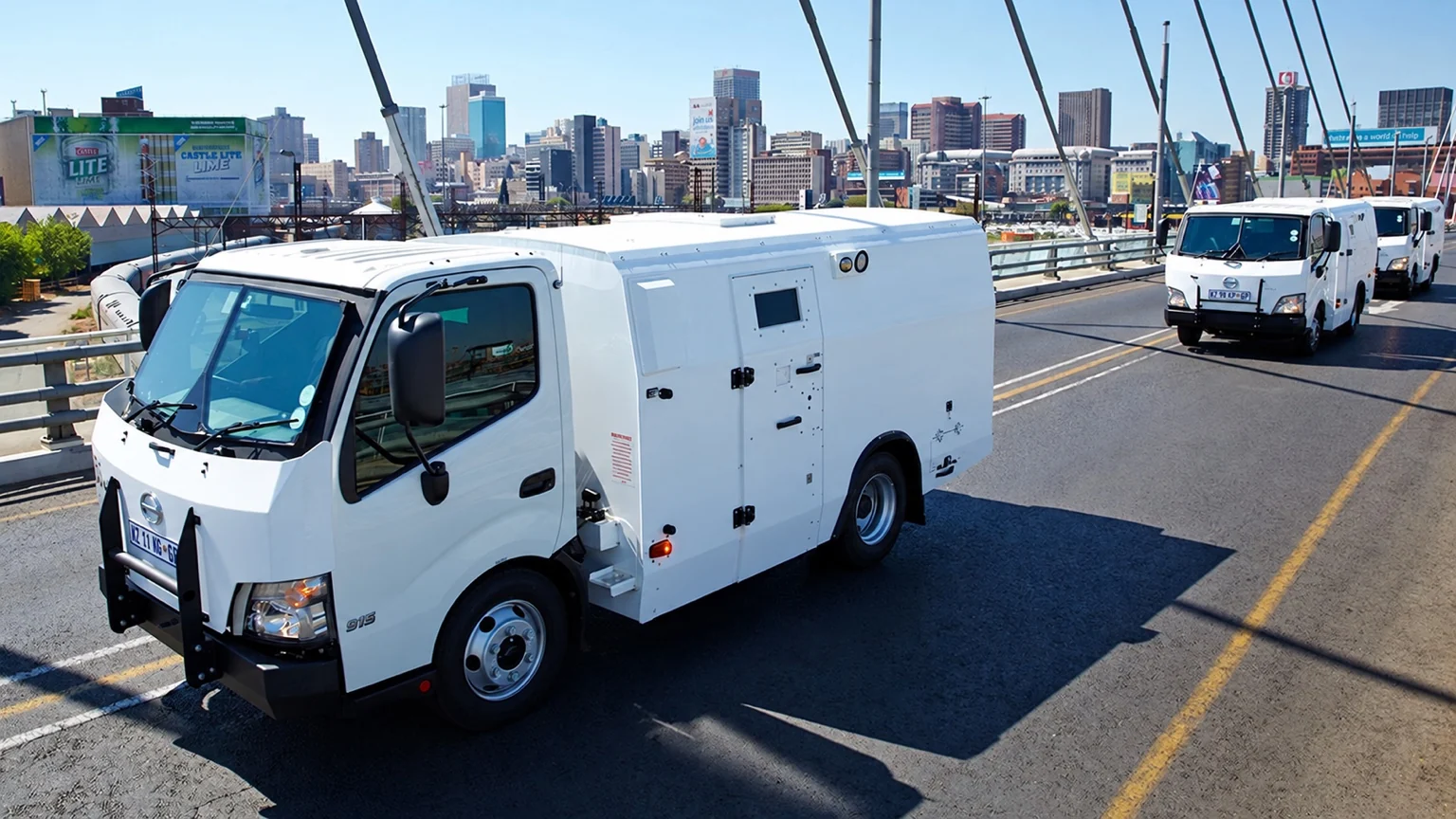White Hino 815 armoured valuables-in-transit vehicle on a city bridge